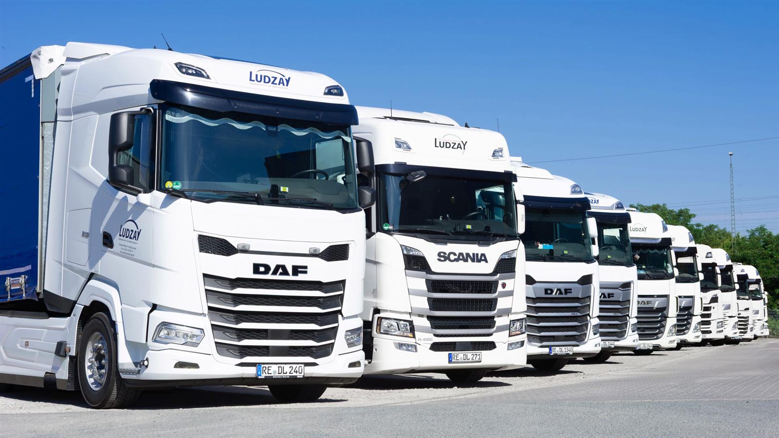 Fuhrpark von Ludzay, mehrere weiße LKW in Reihe